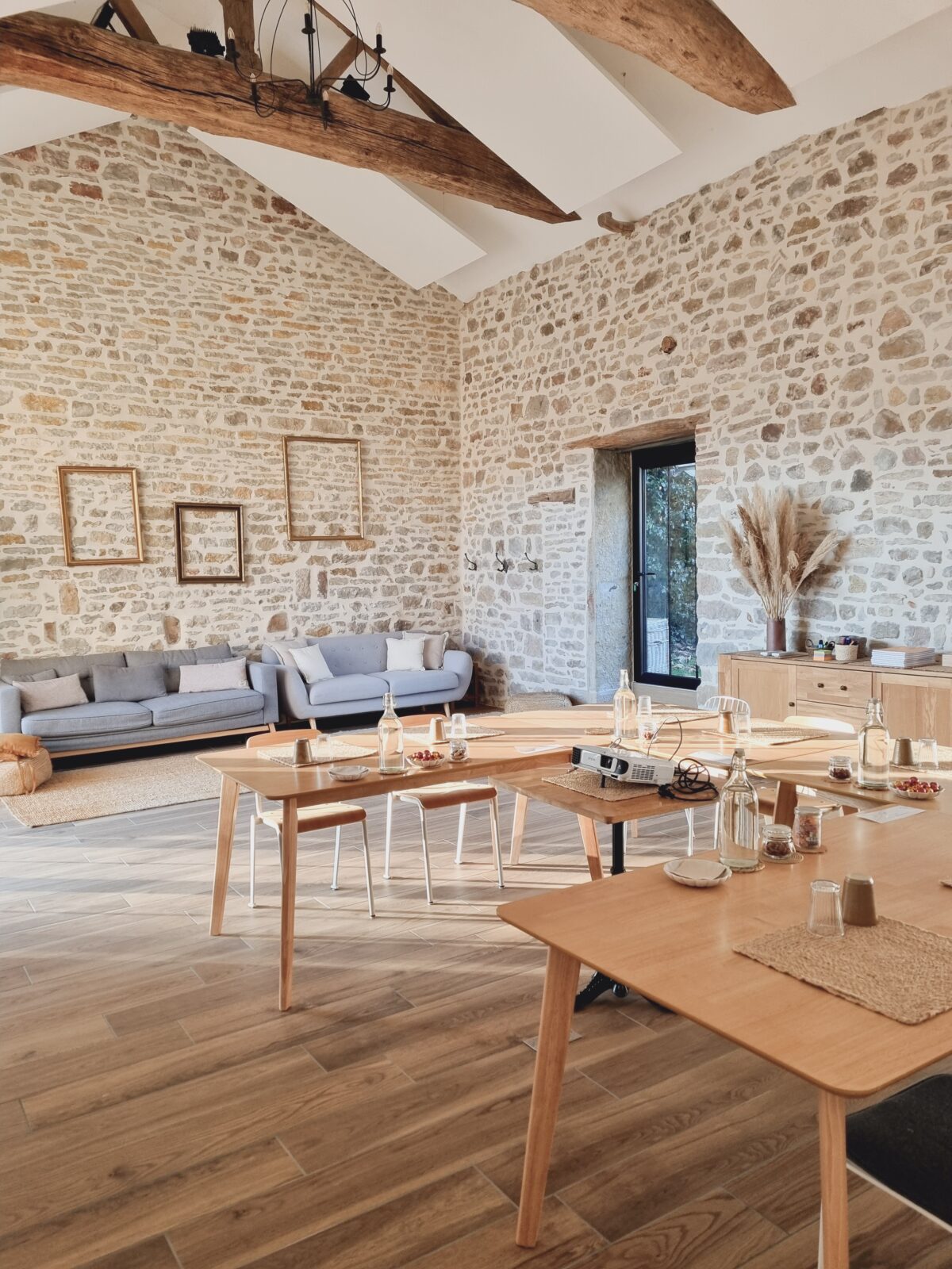 Grande salle de réunion baignée de lumière du jour avec murs en vieille pierre pour séminaires au vert près de Cluny